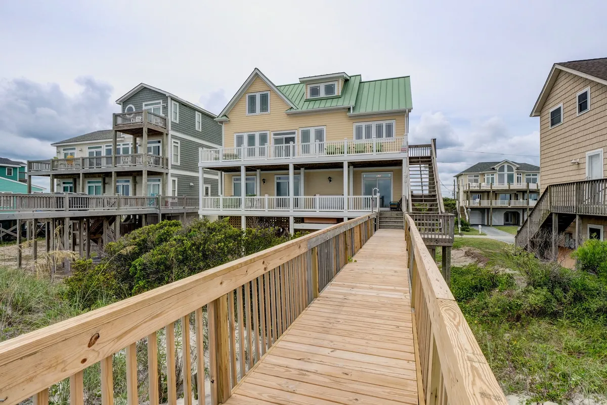 A boardwalk leads to the house, surrounded by greenery and other inviting homes. The scene hints at opportunities for family walks, exploration, and shared adventures in the local area.